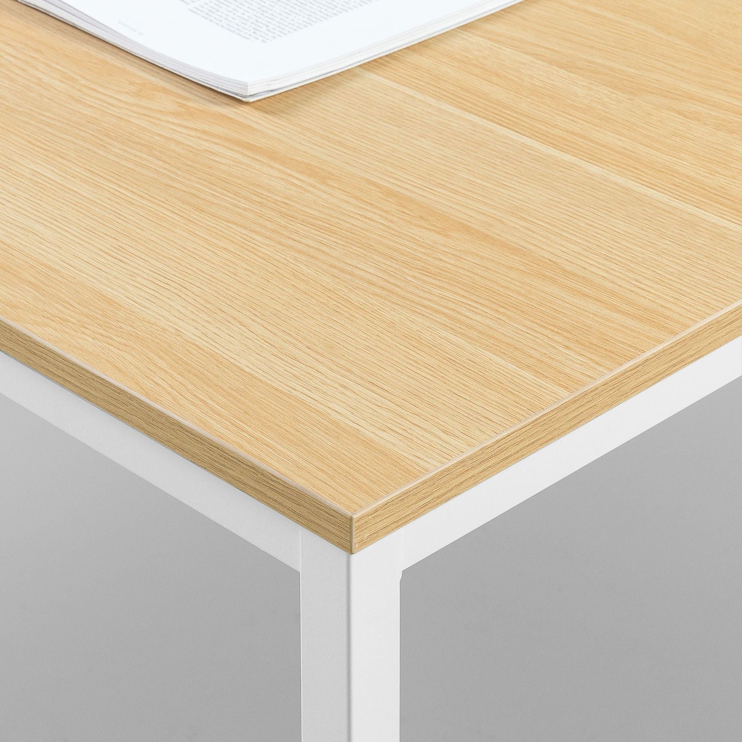 Modern office desk with light wood top and white metal legs, corner view, minimal design
