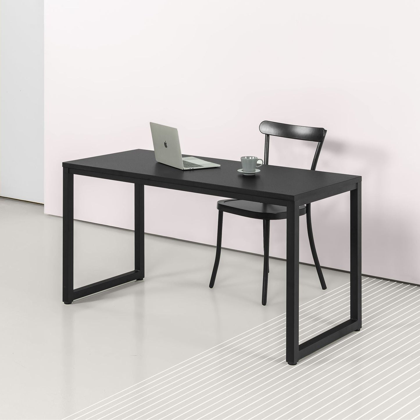 Modern black office desk with metal frame and laptop in minimalist workspace setting