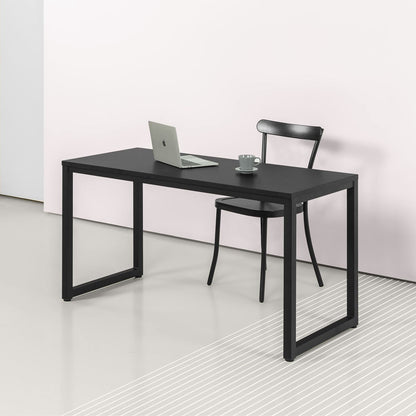Modern black office desk with metal frame and laptop in minimalist workspace setting
