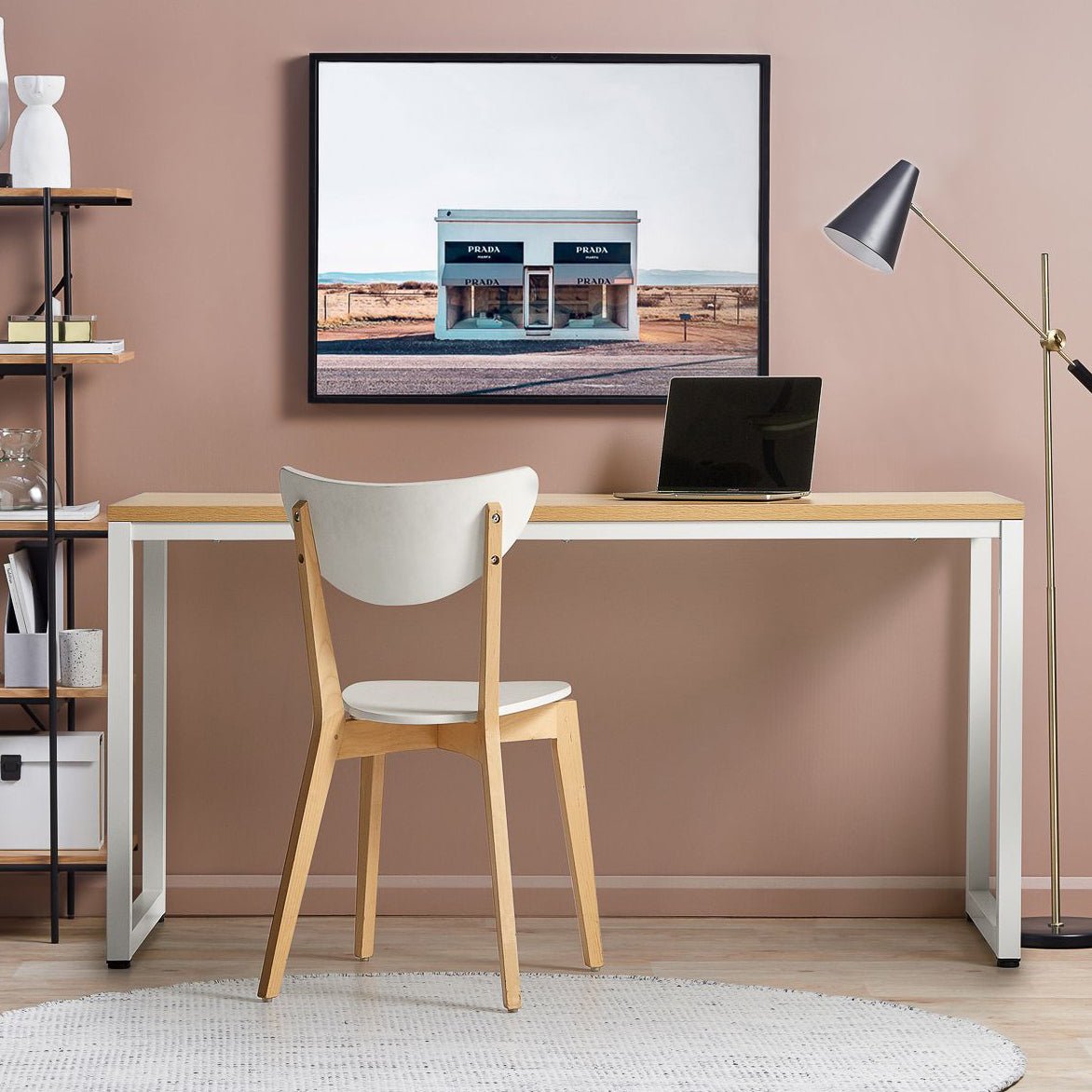 Modern office desk with white metal legs and wooden top, chair, and laptop in a minimalist workspace