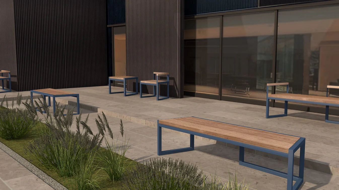 Outdoor seating area with benches and tables near a building with large windows.