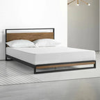 Modern double bed with black metal frame and wood accents in a minimalist bedroom