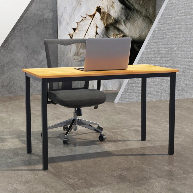 Modern wooden office desk with black metal legs, black mesh chair, and laptop in minimal workspace