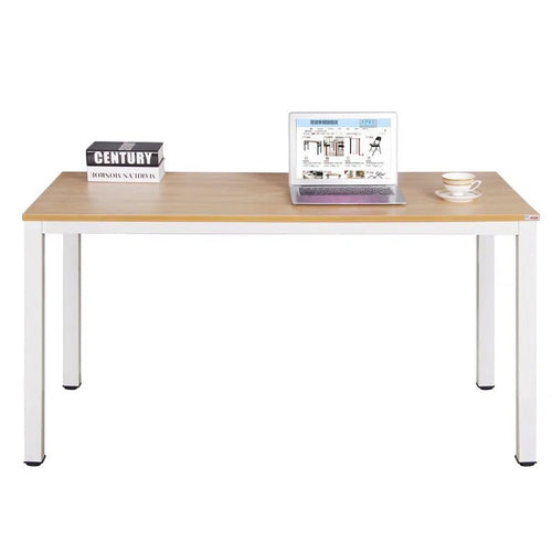 Modern wood and metal desk with a laptop, book, and teacup in a minimal home office setting