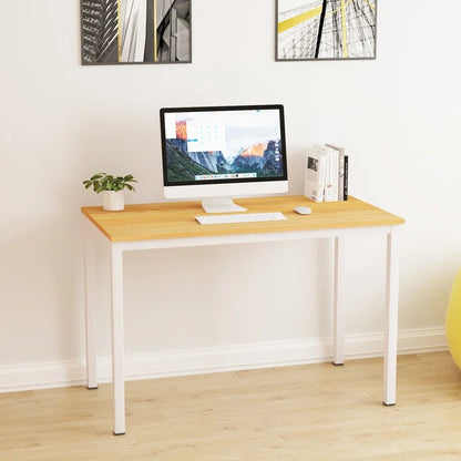 Minimalist home office desk with wood top and white legs, computer, books, and plant