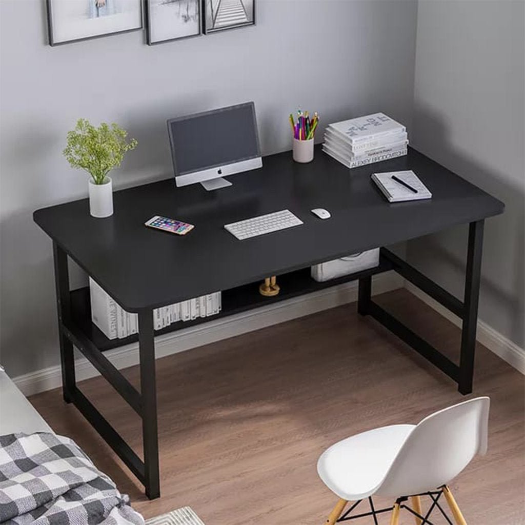 Modern black desk with metal legs, computer, and stationery in a home office setting