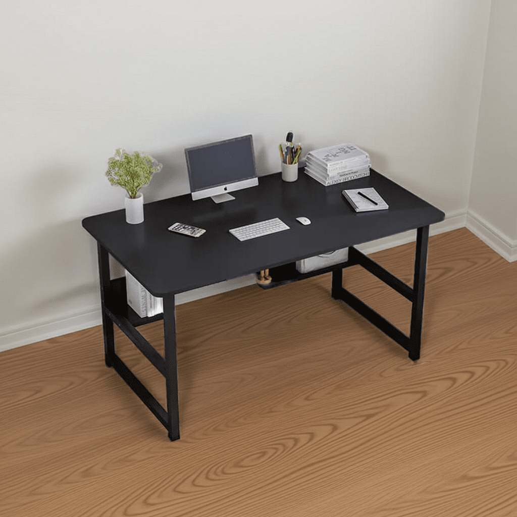 Modern black desk with computer, books, and workspace accessories on wood floor