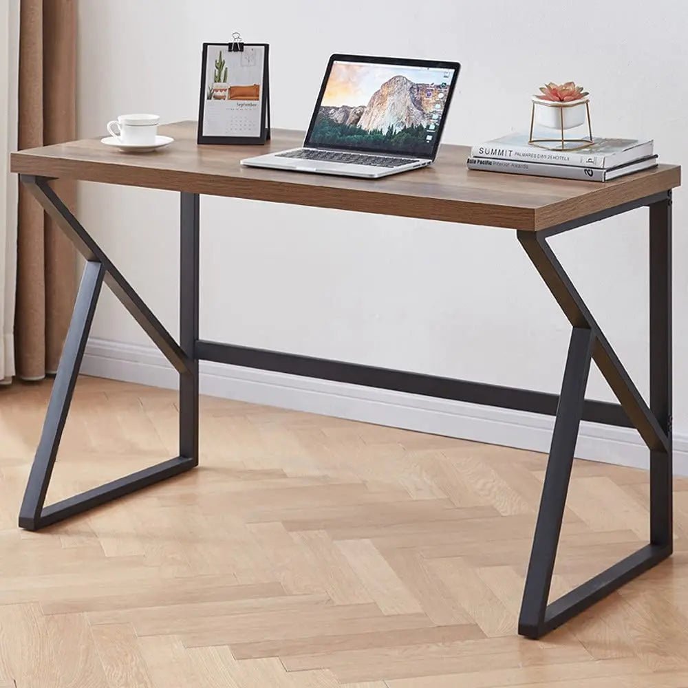 Modern black and brown desk with metal legs, laptop, and decor in a home office setting