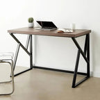 Modern black and brown desk with metal legs and wood top, laptop, book, minimalist decor