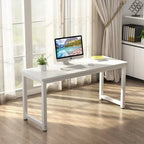 Modern white office desk in bright room with computer, plant, and books
