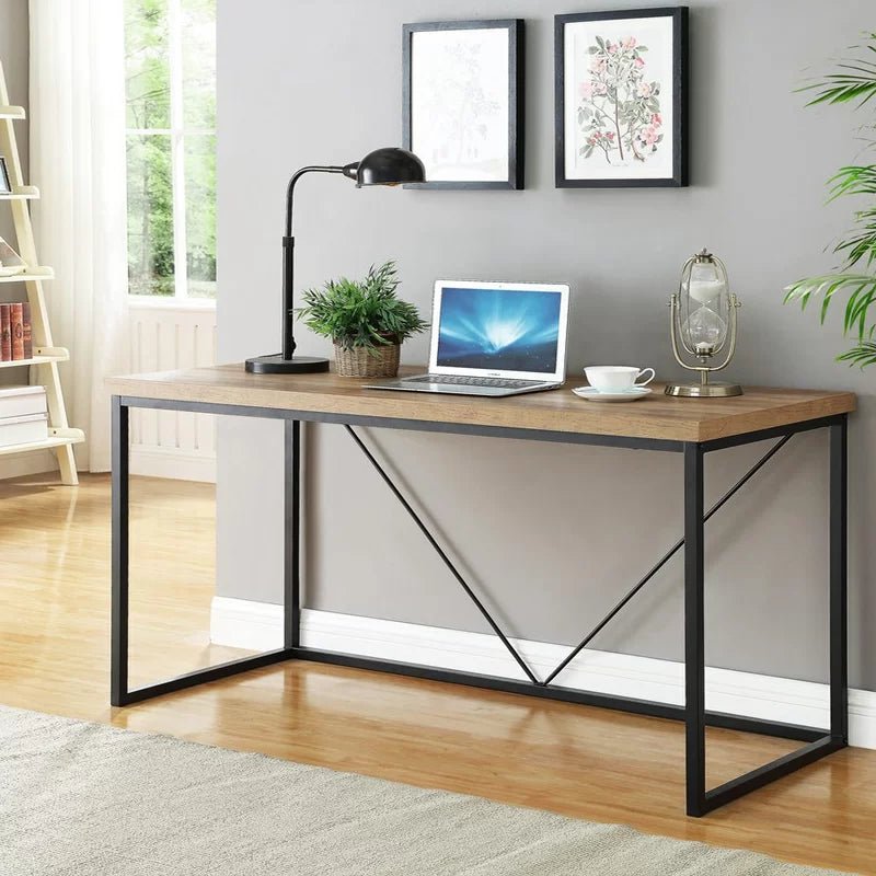 Modern black and brown desk with metal frame, laptop, lamp, and plants in a home office