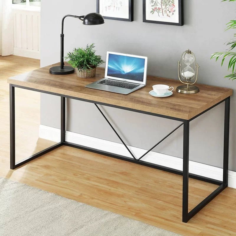 Modern black and brown desk with metal frame, laptop, lamp, and decor in home office setting