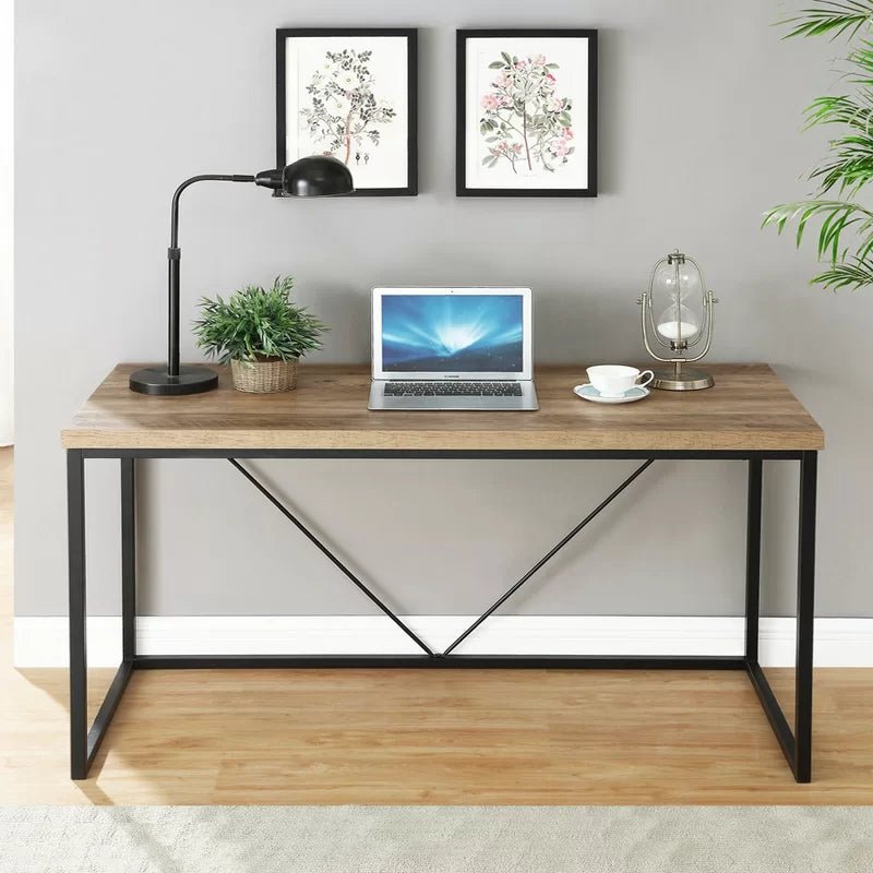 Modern black and brown office desk with laptop, lamp, and decor in a home workspace