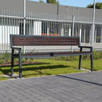 Outdoor modern park bench with metal frame and wooden slats on grass near sidewalk