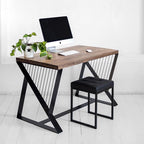 Modern wood and metal desk with computer, black stool, and plant in minimalist room
