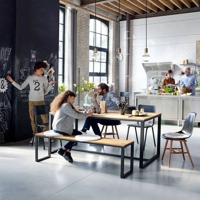 Solid oak dining bench with metal frame in modern open kitchen and dining area, people around table
