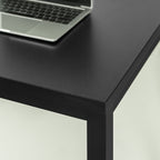 Modern black office desk with metal legs and minimalist laptop setup