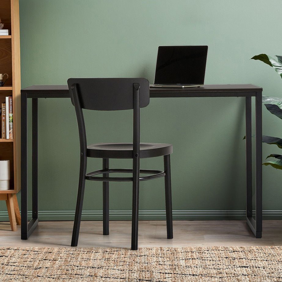 Modern black office desk with laptop and chair in a minimalist home workspace
