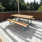 Modern outdoor wooden bench and table set with light blue metal frame on a patio