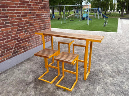 Modern outdoor bar table set with yellow metal frame and wood slats near playground