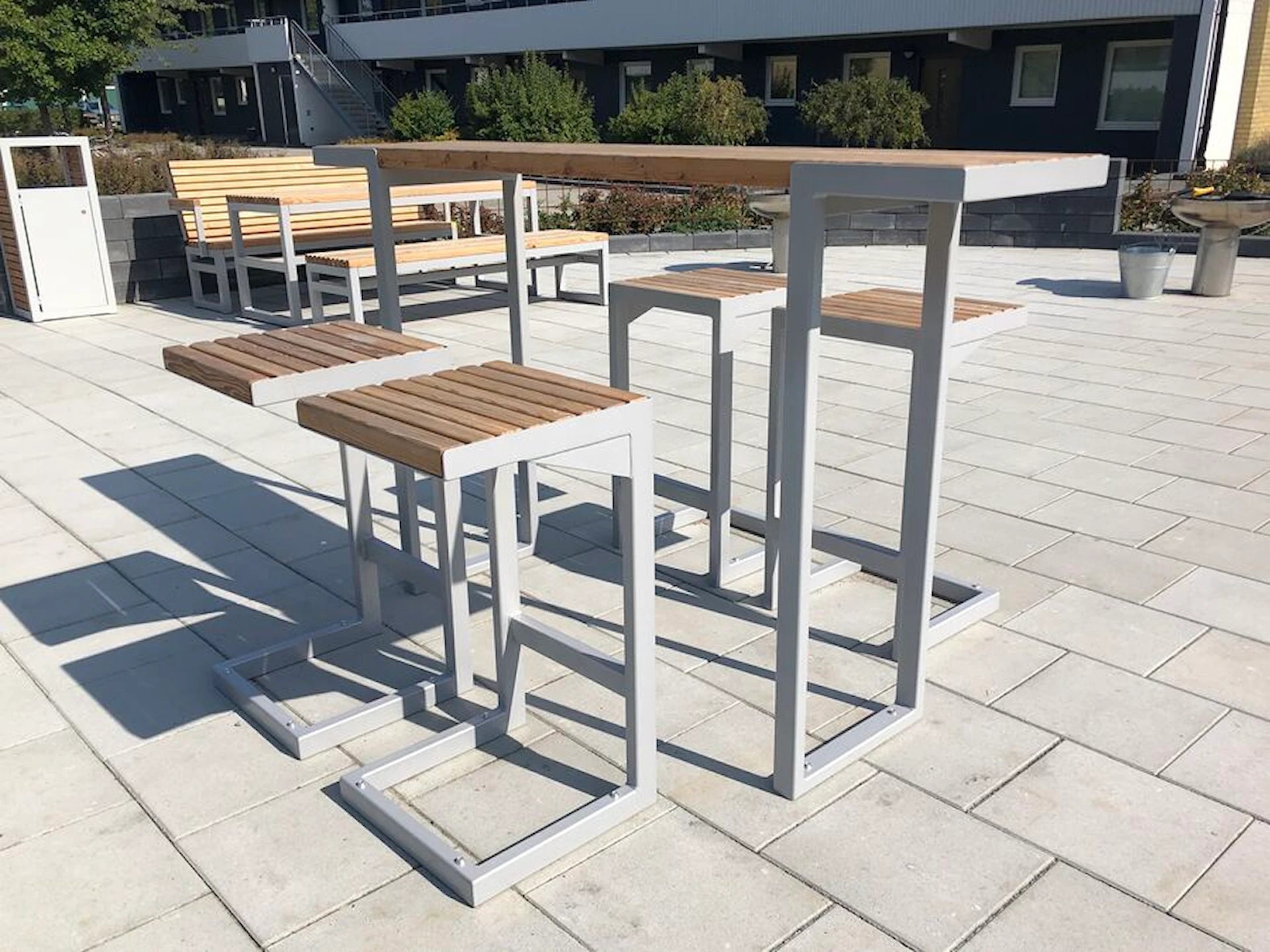 Modern outdoor bar set with wooden seats and tables on a patio