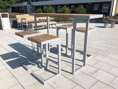 Modern outdoor bar set with wooden seats and tables on a patio
