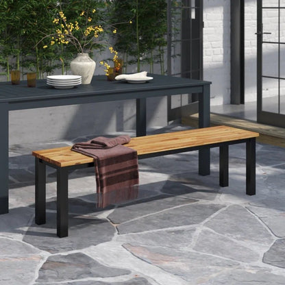 Metal outdoor bench with wood top in a modern patio setting, beside a dining table.