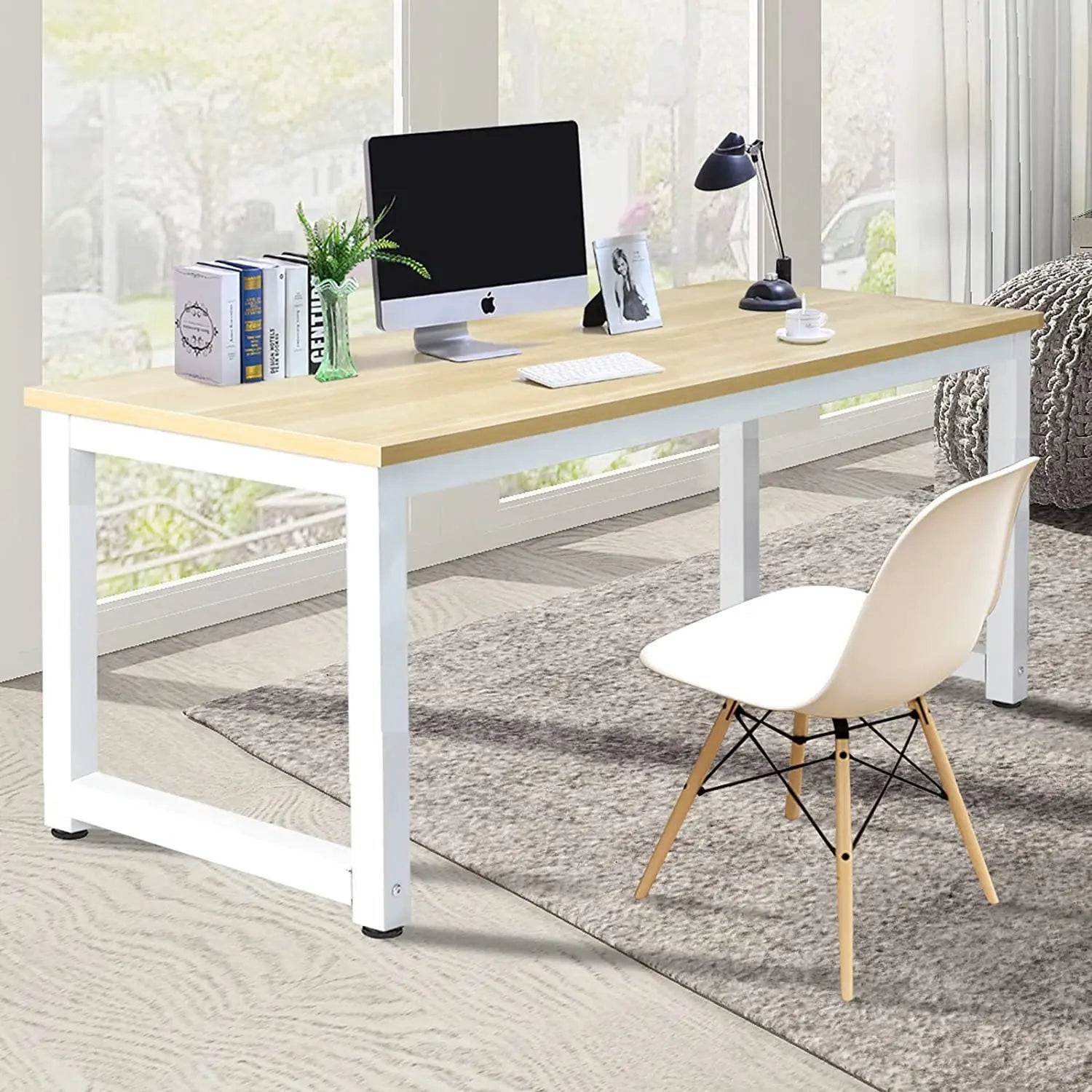 Modern office desk with wood top and white steel frame, styled with computer and chair for home workspace
