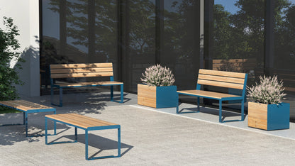 Modern outdoor 3-seater public benches with blue metal frames and wood slats near large windows and planters.