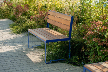 Modern outdoor wooden bench with blue metal frame and backrest in a garden setting