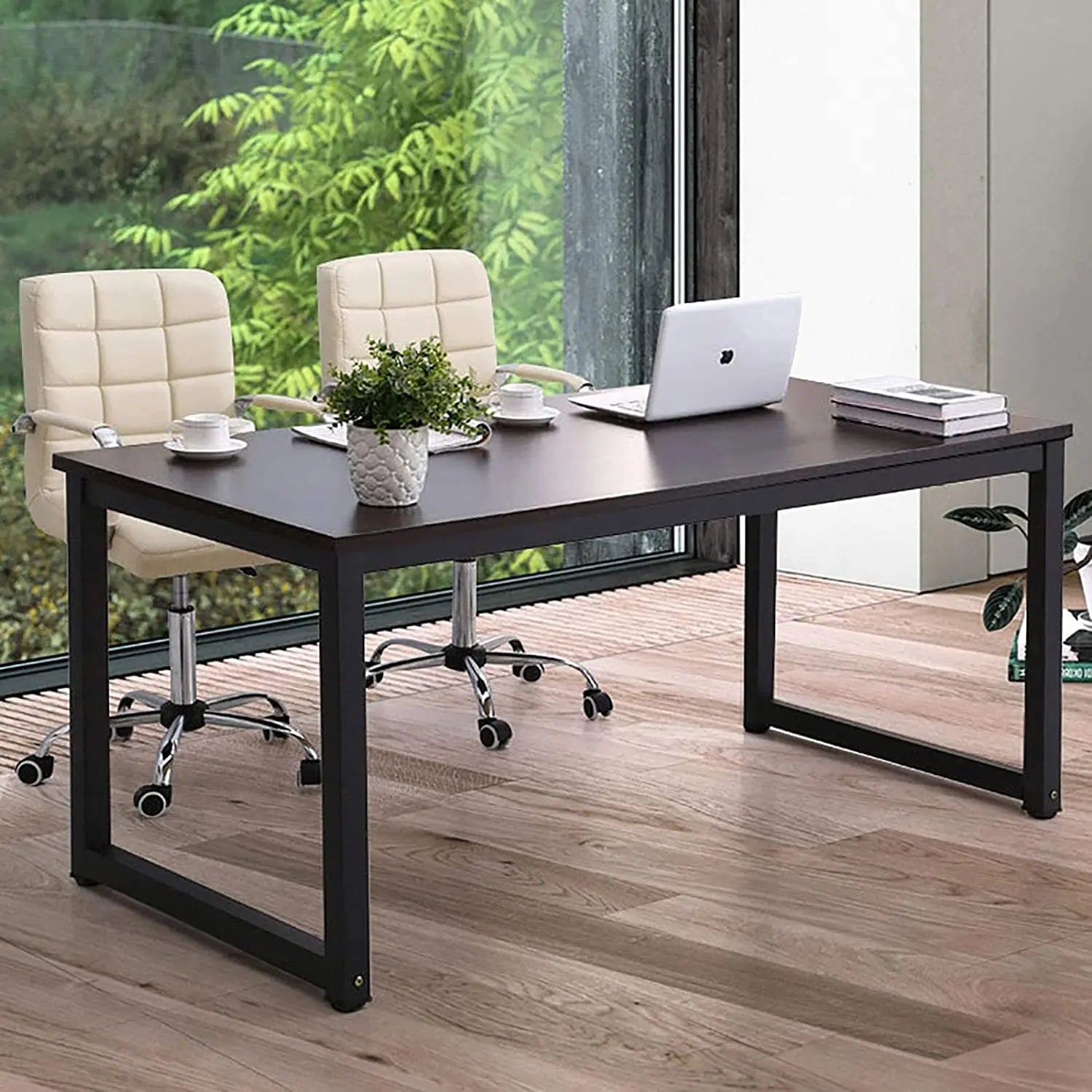 Modern black home office desk with metal frame, laptop, cream chairs, and potted plant