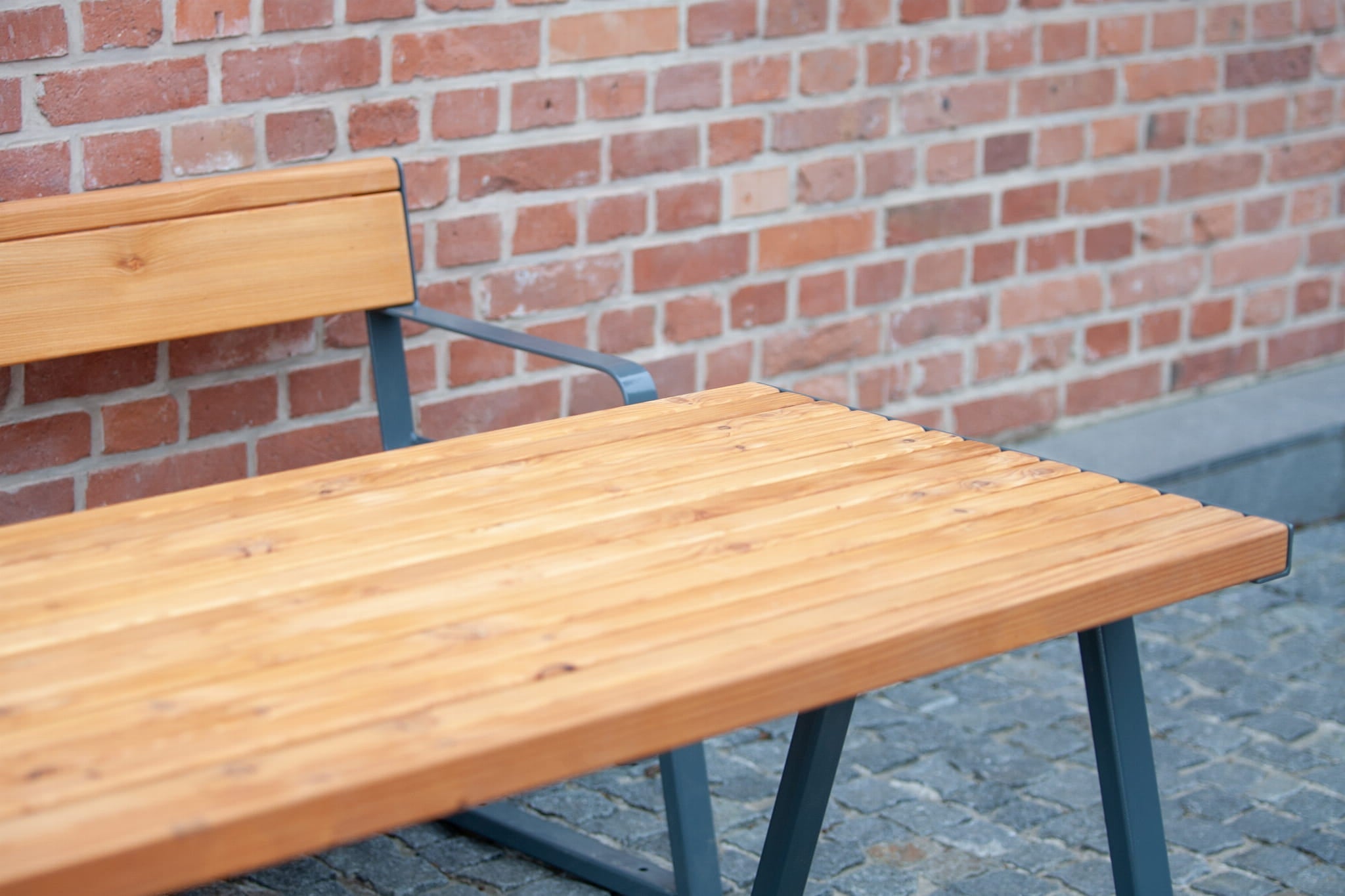 Sturdy outdoor wooden table and bench set with metal frame on stone patio