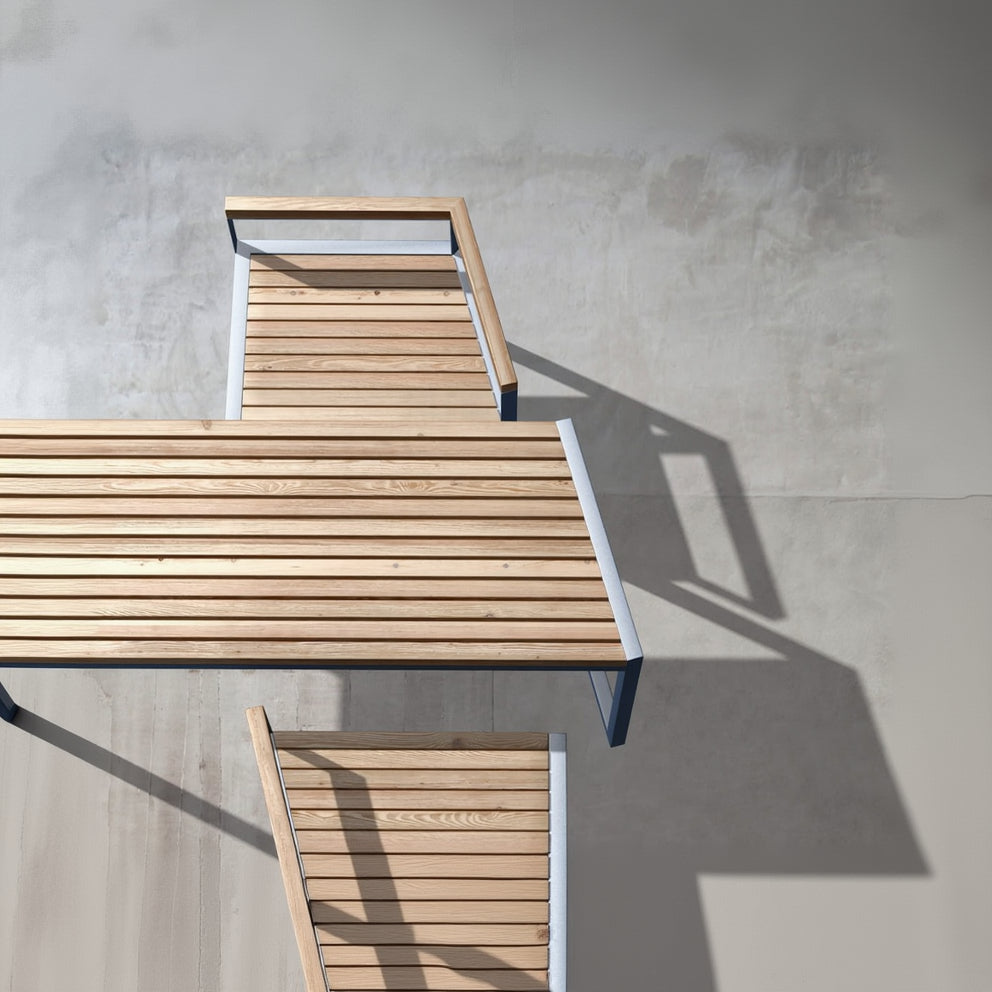 Modern outdoor wooden table and bench set with metal frame on concrete patio