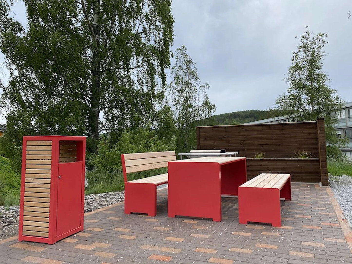 Red and wood outdoor wastebasket with matching picnic table and benches on patio