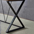 Modern black steel desk with X-frame base and brown tabletop on light carpet