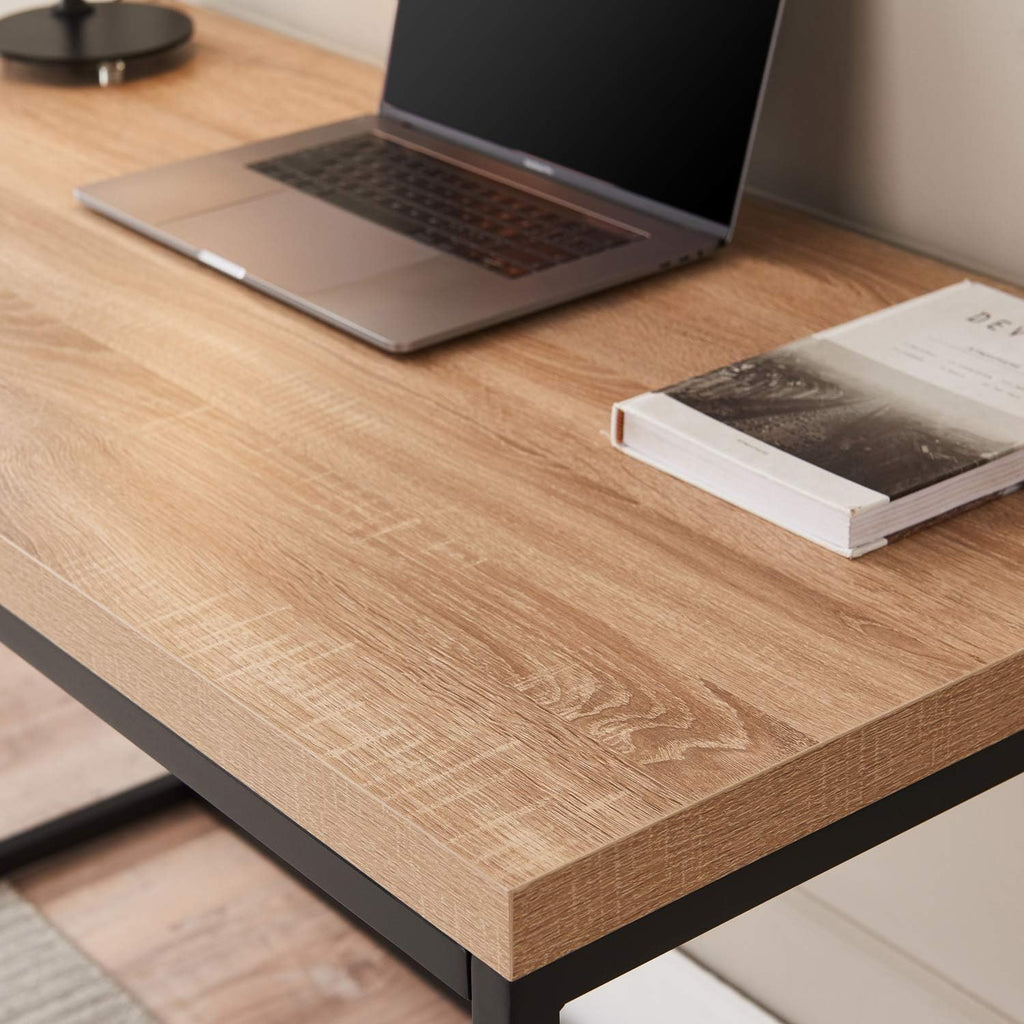 Modern wood desk with black metal legs, laptop, and book in a minimalist home office