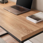 Modern wood desk with black metal legs, laptop, and book in a minimalist home office