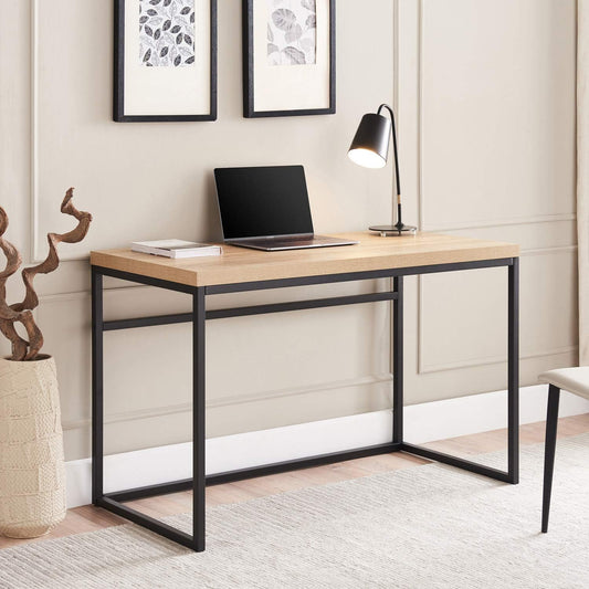 Modern wood and metal desk with laptop, lamp, and decor in a minimalist home office