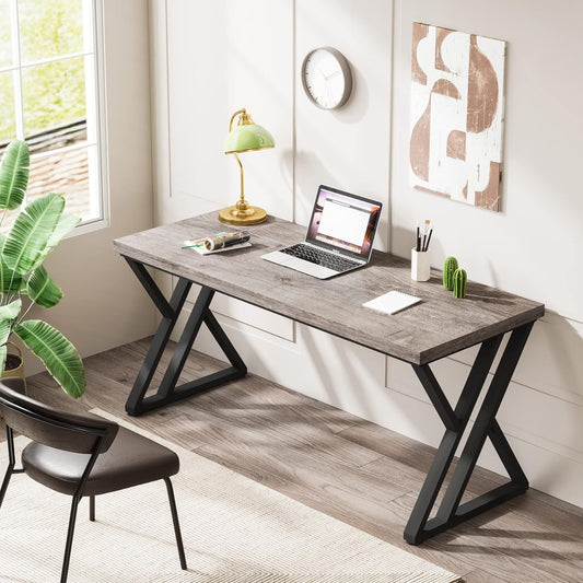 Modern computer desk with sturdy metal legs, wood surface, laptop, and decor in a bright home office.
