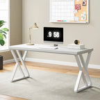 Modern white computer desk with X-frame legs in a home office, featuring a monitor, lamp, books, and decor.