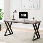 Modern computer desk with black metal legs, wood top, monitor, and lamp in a bright room